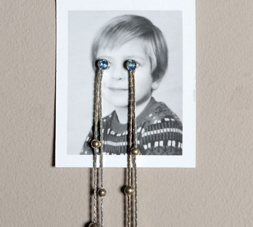 Jonathan Monk, In Edition (to tears), 2006 Passport photograph and earrings; edition 47 of 50 3 ⅜ x 1 ¾ in. Linda Pace Foundation Collection, Ruby City, San Antonio, Texas